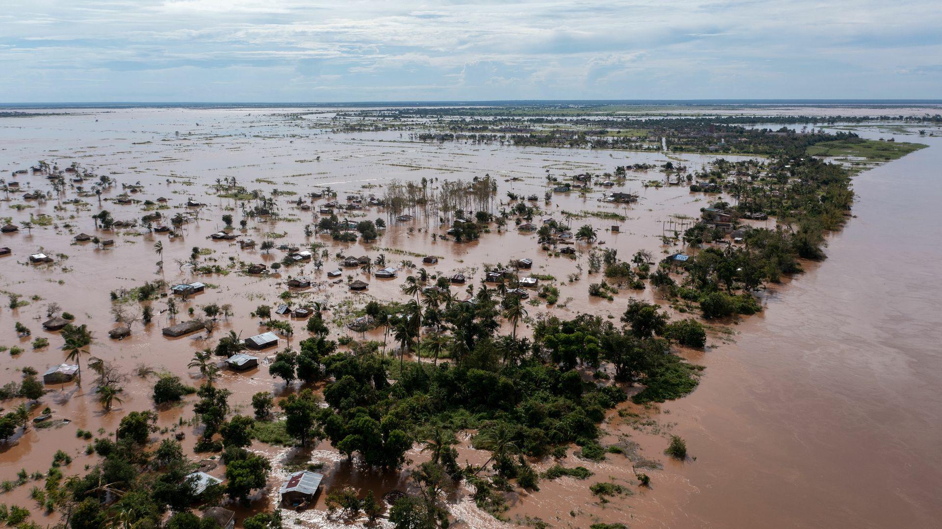 Aerial view of flooded land with scattered houses and trees submerged in water after a heavy flood.