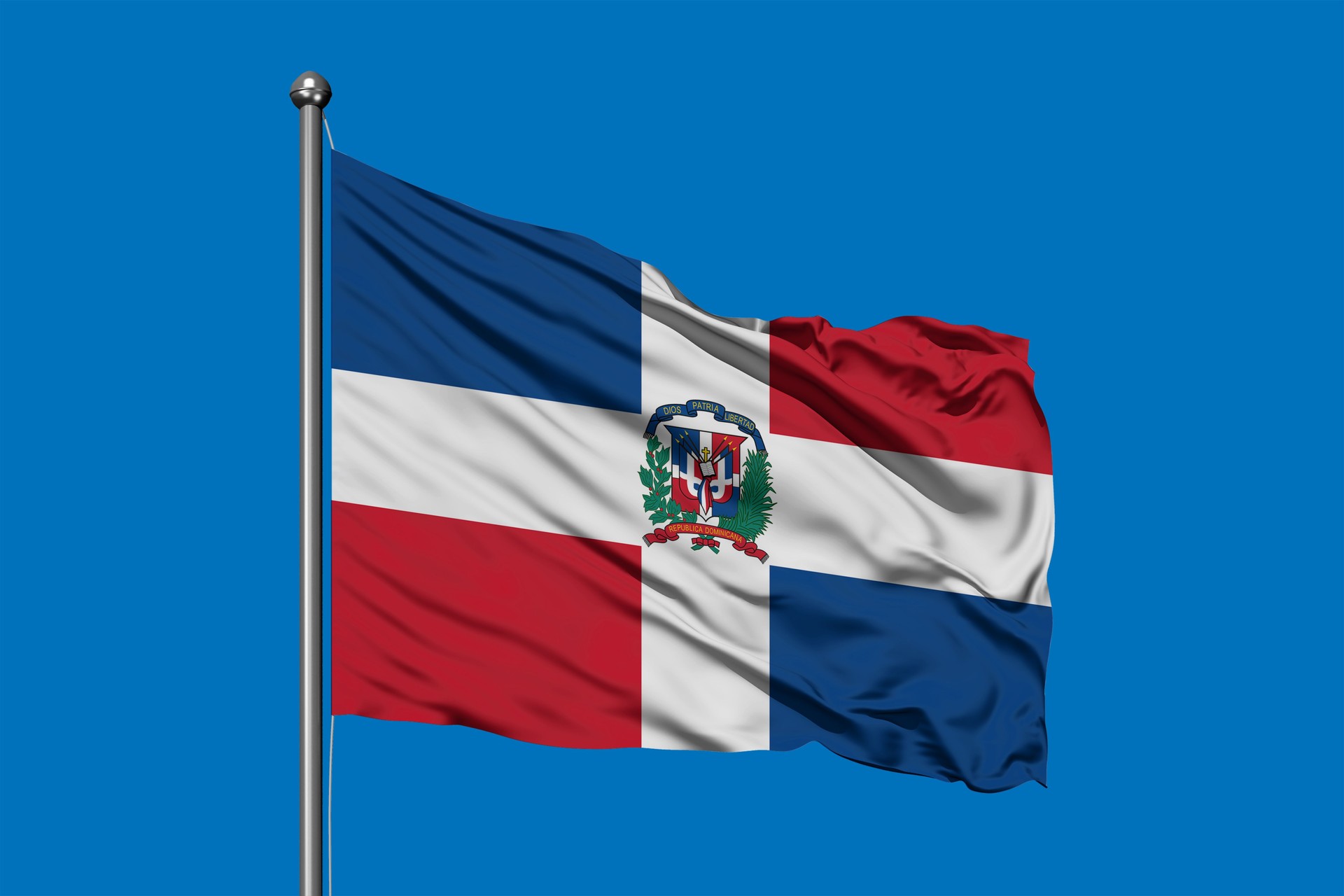 Flag of Dominican Republic waving in the wind against deep blue sky. Dominican flag.