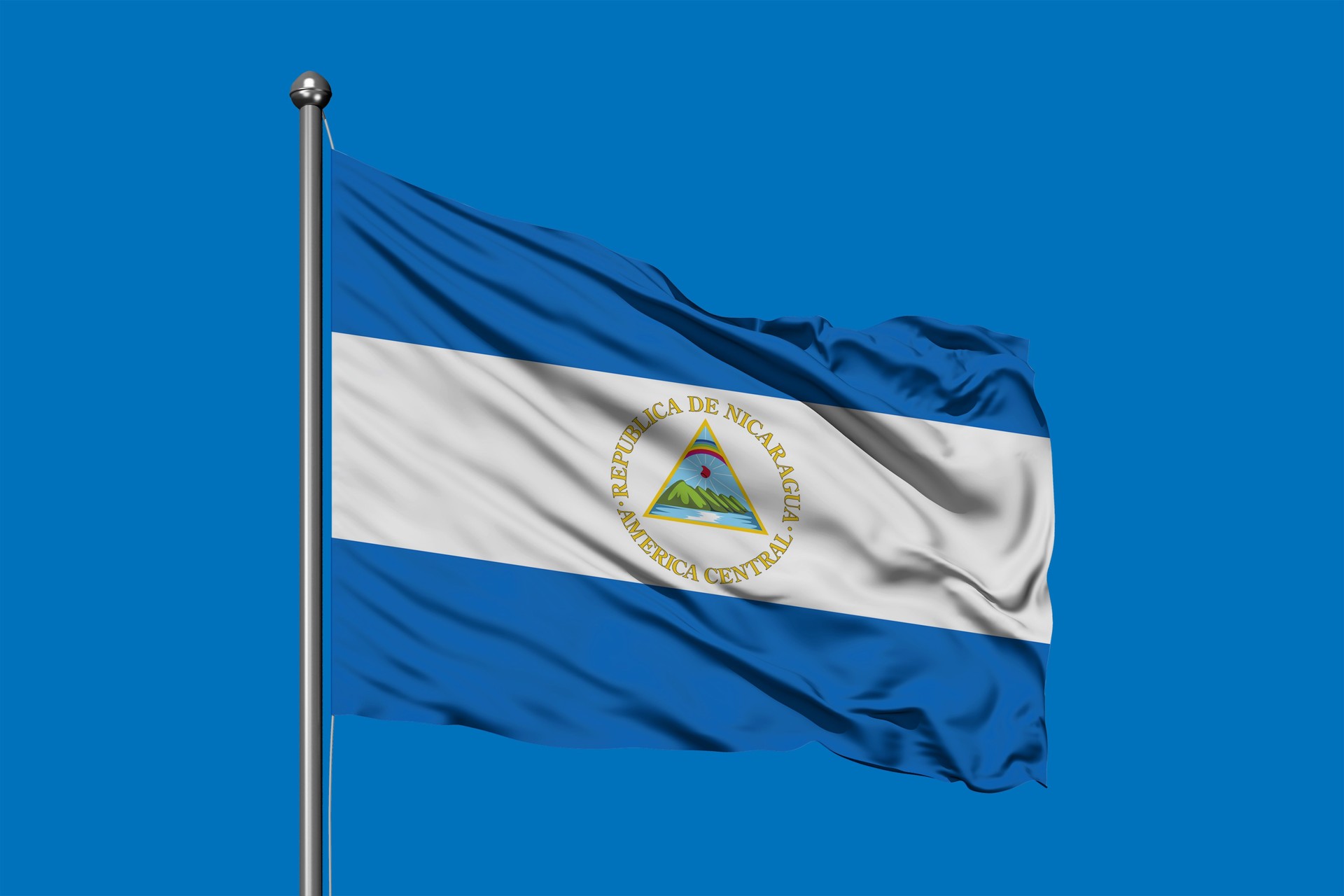 Flag of Nicaragua waving in the wind against deep blue sky. Nicaraguan flag.